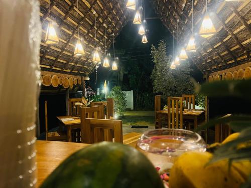 a restaurant with a table and chairs and lights at Turtle Wood Cabin in Tangalle