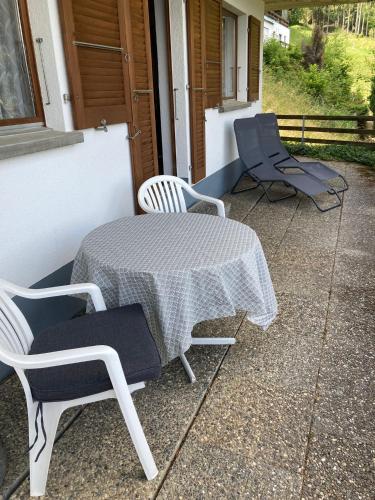 two chairs and a table on a patio at Friedmatte Breathtaking View in Beatenberg