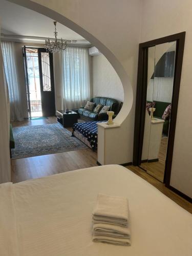 a room with a bed and a living room at Guest house Medea in Kutaisi