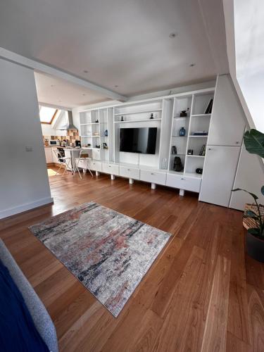 a living room with a large television and a hard wood floor at Studio flat in the heart of Hampstead, London in London