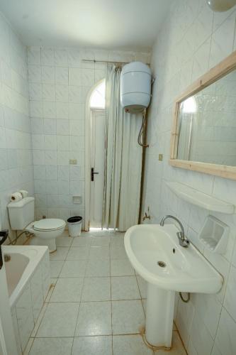 a white bathroom with a sink and a toilet at Beach house First Row sea view at Santa Monica next to Almaza Bay in Marsa Matruh
