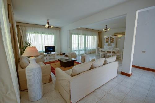 a living room with a white couch and a table at Beach house First Row sea view at Santa Monica next to Almaza Bay in Marsa Matruh
