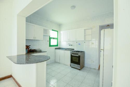 a kitchen with white cabinets and a stove top oven at Beach house First Row sea view at Santa Monica next to Almaza Bay in Marsa Matruh