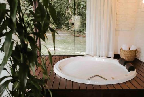 a bath tub sitting in front of a window at Casa de campo em Joinville com Hidromassagem e Lareira in Joinville