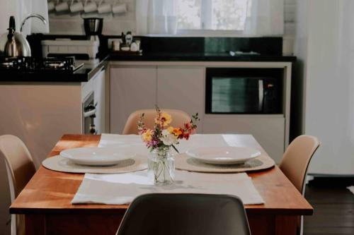a kitchen with a table with plates and flowers on it at Casa de campo em Joinville com Hidromassagem e Lareira in Joinville