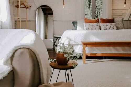 um quarto com uma cama branca e uma mesa com uma mesa em Casa de campo em Joinville com Hidromassagem e Lareira em Joinville