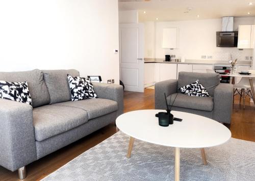 a living room with a couch and a table at Lovely Charming 2-Bedroom Apartment in Bow London in London
