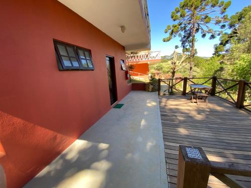 a house with a wooden walkway next to a building at Pousada Sotaque Mineiro in Cunha