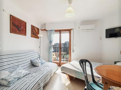 a bedroom with a bed and a table and a window at Coqueto estudio con Vistas al Mar in Torremolinos