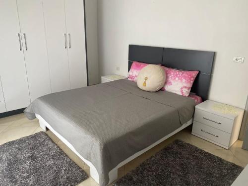 a bedroom with a large bed with pink pillows at Rooms for rent Gezim Ismailaj 