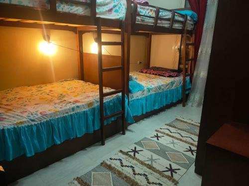 a bedroom with two bunk beds with blue sheets at Lasirina palm beach for families only in Ain Sokhna