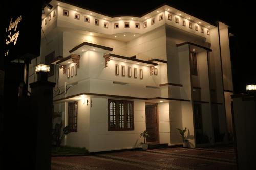 a large white building with lights on it at night at SkyLounge Residency in Trivandrum