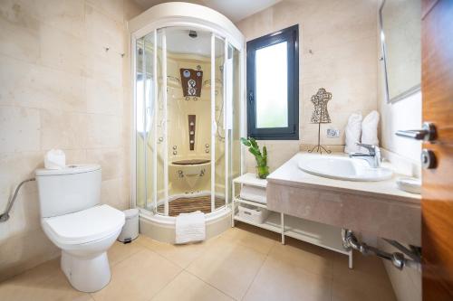 a bathroom with a toilet and a sink and a shower at Villa LanzaCosta Golf in Teguise