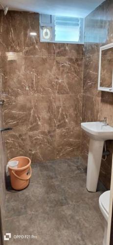 a bathroom with a sink and a toilet at Royal Destiny Resort in Malaiyāndipattanam