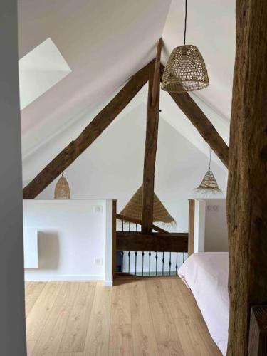 - une chambre dotée de parquet et de poutres apparentes dans l'établissement Gite les bois d Orceil, à La Gohannière