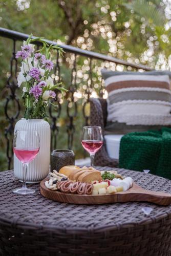 een tafel met een bord eten en twee glazen wijn bij LohonoStays Colina Villa D in Vagator