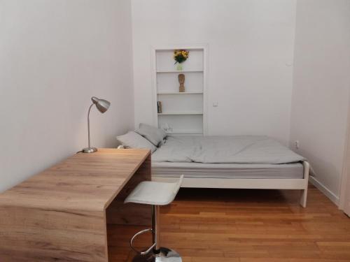 een kleine slaapkamer met een bed en een bureau bij Downtown 3 BDR Charm - walk to all attractions in Bratislava