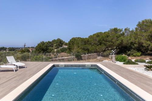 a swimming pool with a wooden deck next to at Colonies in Ses Salines
