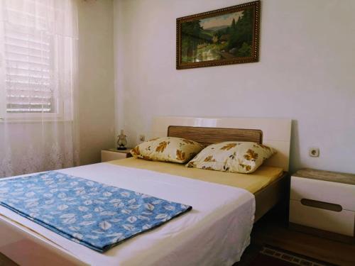 a bedroom with a bed and a picture on the wall at Apartment Karlobag/Velebit Riviera 34907 in Karlobag