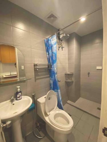 een badkamer met een toilet, een wastafel en een douche bij Condo in Tomas Morato, Quezon City in Manilla