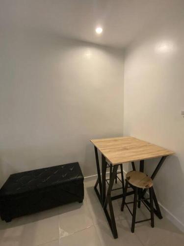 een tafel en stoel in een kamer met een tafel en een bank bij Condo in Tomas Morato, Quezon City in Manilla