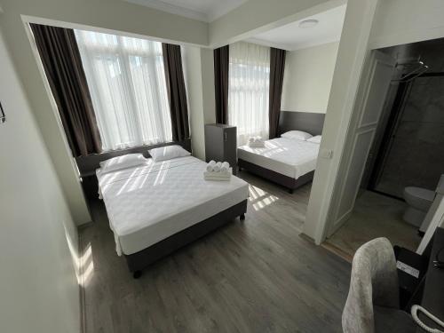 a hotel room with two beds and a bathroom at Maritsa Hotel in Edirne