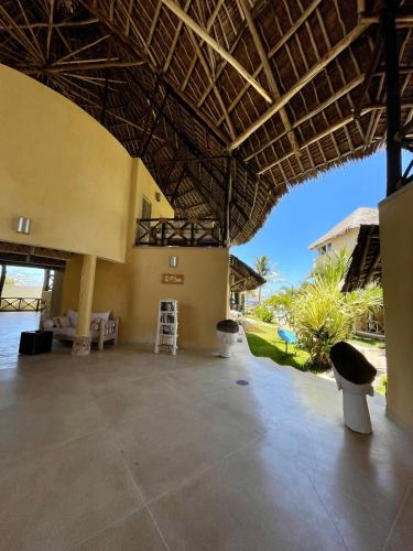 a large room with a large ceiling and a room with a patio at Mawe Zuri Resort in Watamu