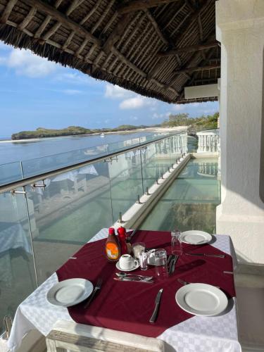 a dining table with a view of the water at Mawe Zuri Resort in Watamu