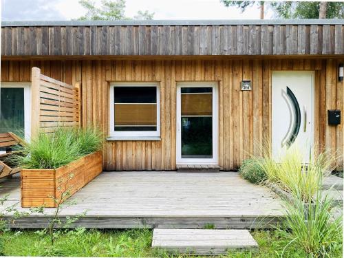 a wooden house with a wooden deck and two windows at Bungalow 314 in Joachimsthal