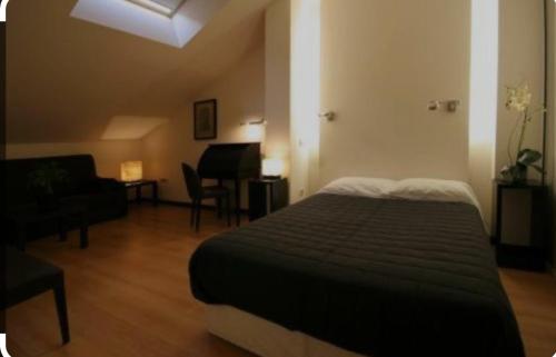 1 dormitorio con 1 cama y sala de estar con piano en hotel asador versus, en Burgos