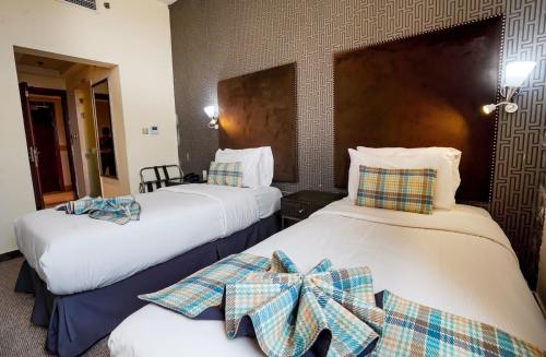 a hotel room with two beds with bows on them at Cube Hotel Dubai formerly Al Buraq Hotel Al Ras in Dubai
