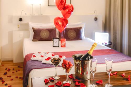 a bedroom with a bed with a bottle of champagne and balloons at Comfort Suites Alphaville in Barueri