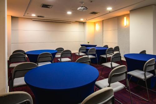a conference room with blue tables and chairs at Comfort Suites Alphaville in Barueri