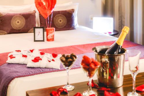 a bed with a table with a bottle of wine and glasses at Comfort Suites Alphaville in Barueri