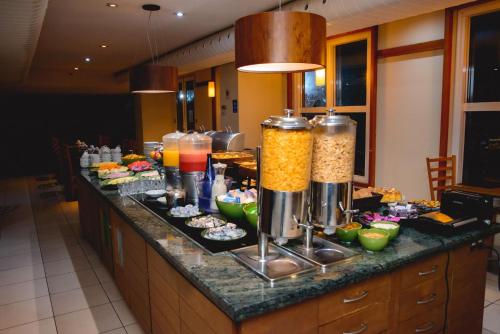 a kitchen with a counter with food and drinks at Comfort Suites Alphaville in Barueri