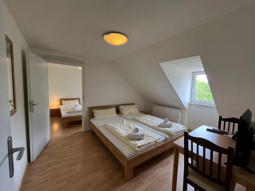um quarto com uma cama, uma mesa e uma janela em Alter Wirt Thalkirchen em Munique
