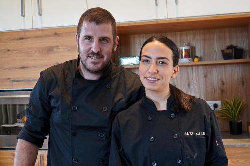 a man and a woman standing in a kitchen at THE HOUSE ROSH PINA - 2BRM WITH POOl in Rosh Pinna