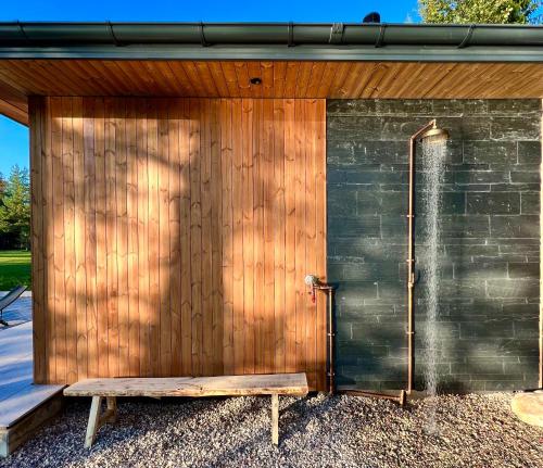 a wooden building with a shower and a bench at Villa The Lake in Mindūnai