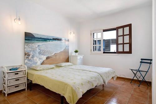 - une chambre avec un lit et une peinture murale dans l'établissement El Charco Azul, à Charco del Palo