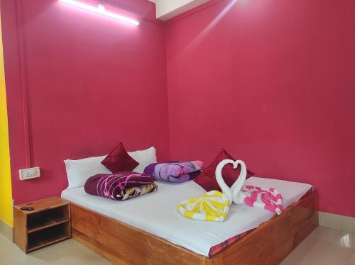 Dirang DzongにあるHotel Zambalaの赤い壁のドミトリールームのベッド1台分です。