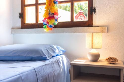 a bedroom with a bed with a window and a lamp at Torre Cappavecchia in Molfetta