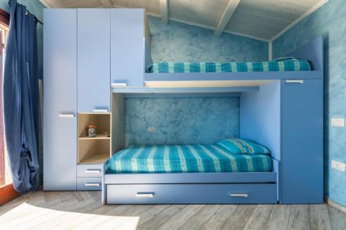 a bedroom with a bunk bed with blue walls at Luxury Apartment Simius in Villasimius