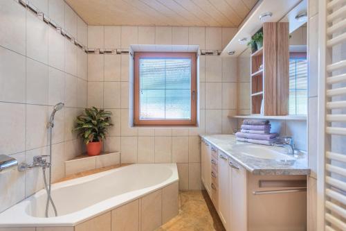 a bathroom with a tub and a sink at Ferienwohnung Hörbiger in Wildschönau