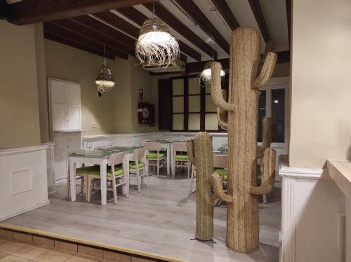 a dining room with a table and a cactus sculpture at Hostal Loreto in Denia