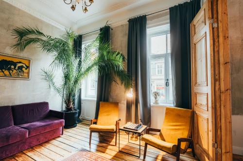 un soggiorno con un divano viola e due sedie di Miller`s place a Riga
