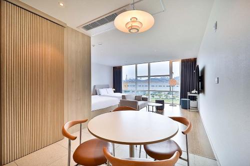 a room with a bed and a table and chairs at Browndot Signature Hotel in Changwon