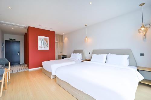 a hotel room with two beds and a red wall at Browndot Signature Hotel in Changwon