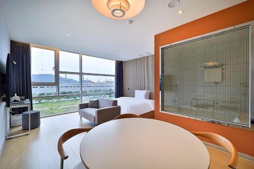 a hotel room with a bed and a table and chair at Browndot Signature Hotel in Changwon