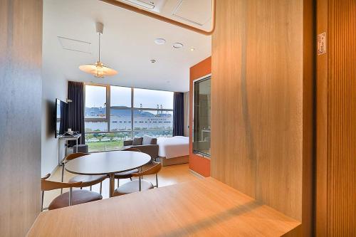 uma sala de estar com uma mesa e um quarto em Browndot Signature Hotel em Yongjae