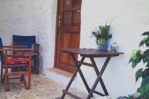 een tafel met een plant naast een deur bij Kaiti’s House in Arkoi